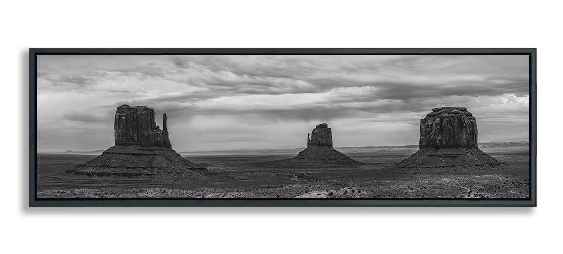 Monument Valley panoramic metal print in black and white three classic desert buttes under dramatic clouded sky