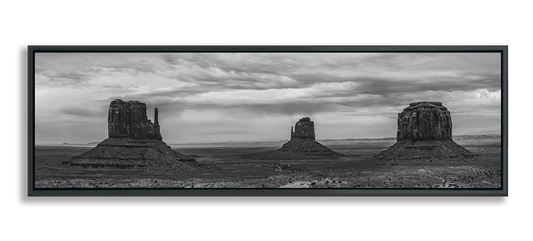 Monument Valley panoramic metal print in black and white three classic desert buttes under dramatic clouded sky