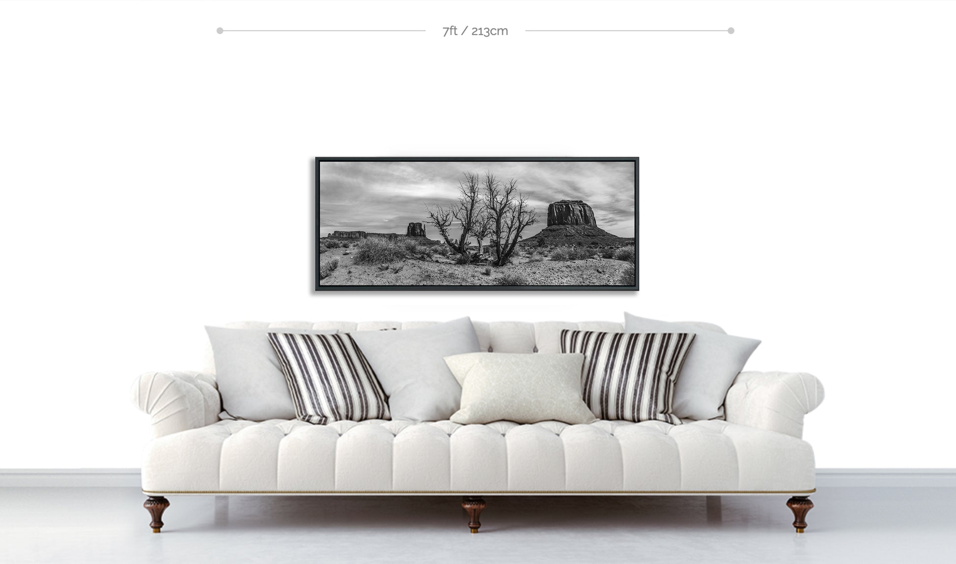 Monument Valley Fine Art Print displayed on white wall above white sofa with pillows