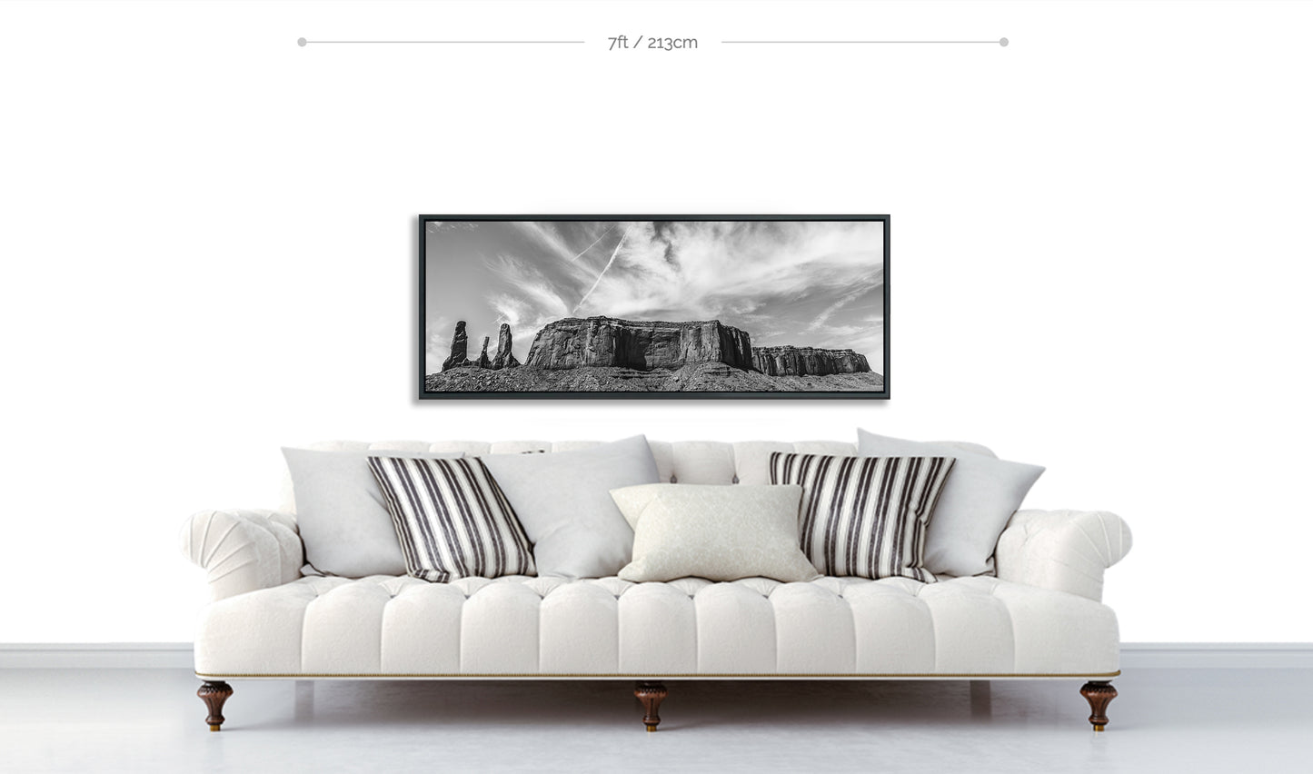 Monument Valley Three Sisters panoramic Print displayed hanging above white sofa with cushions