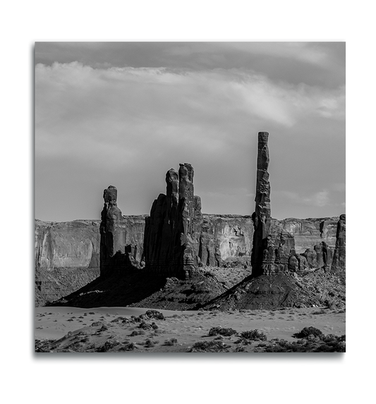 Monument Valley Square Print on Metal slender rock formations against desert rock ridge in background black and white