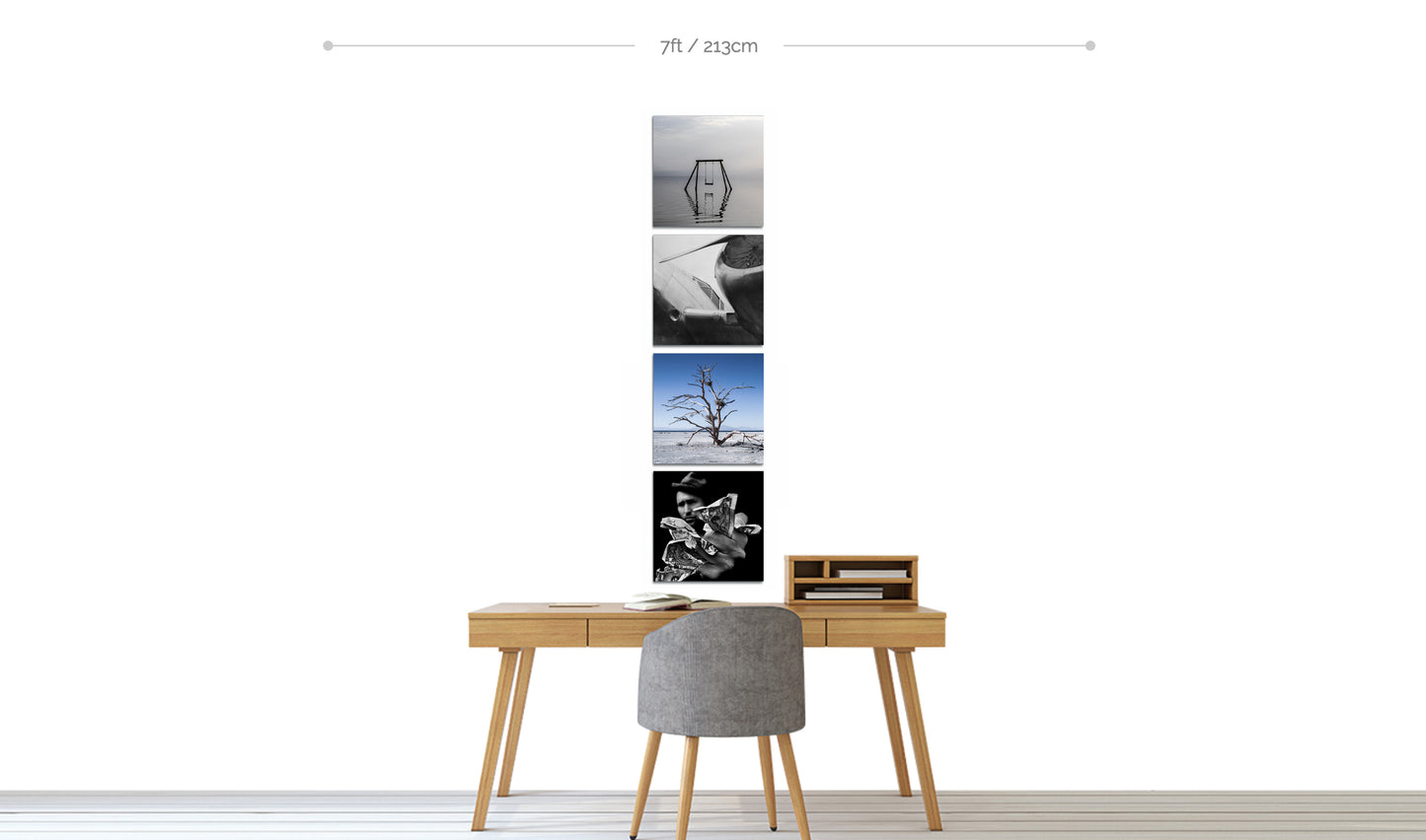 Set of four fine art square prints in color and black and white displayed in vertical line of wall above home office desk with chair