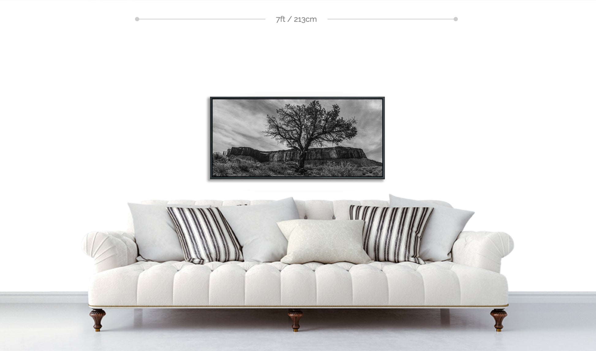 Monument Valley desert tree in front of buttes Fine Art Photograph Metal Print displayed above white sofa with patterned pillows 