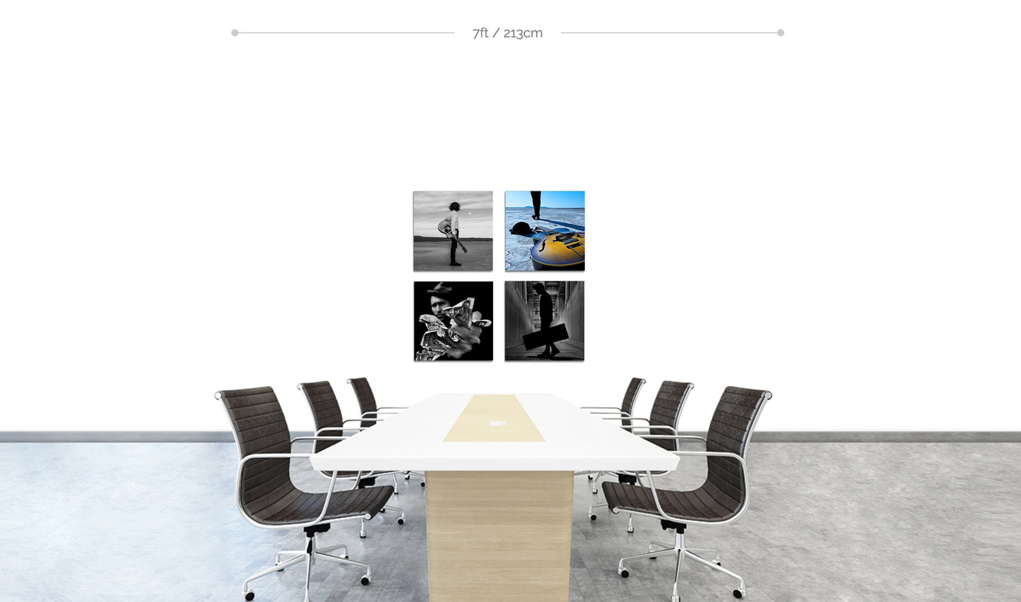 Set of four fine art square metal prints arranged in square formation on white wall behind boardroom table with chairs