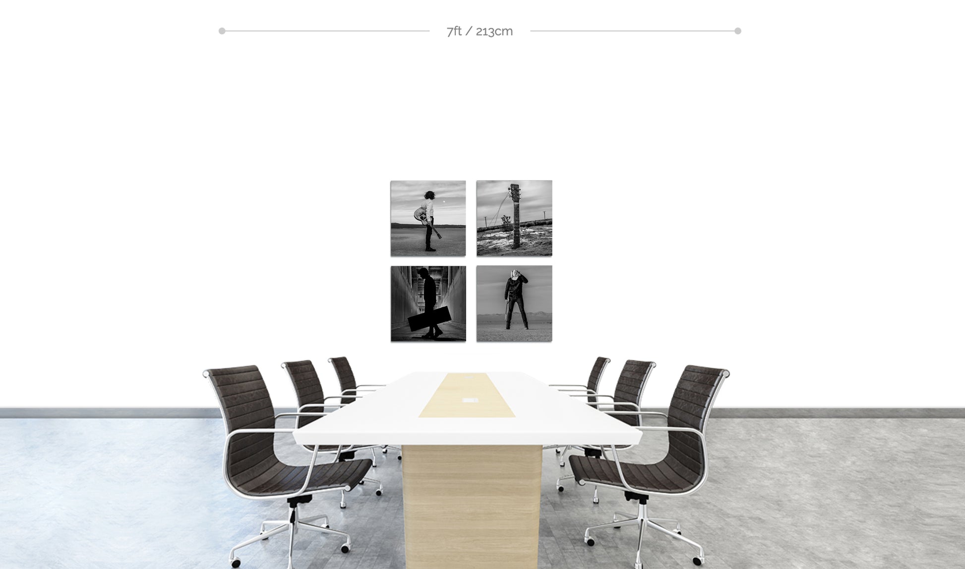 Set of four square metallic prints in black and white displayed in square formation on white wall behind long boardroom table with chairs