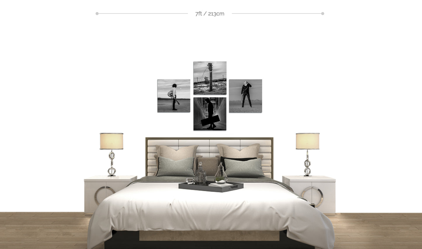 Set of four fine art black and white metal prints arranged in cross formation on white wall above bed in bedroom