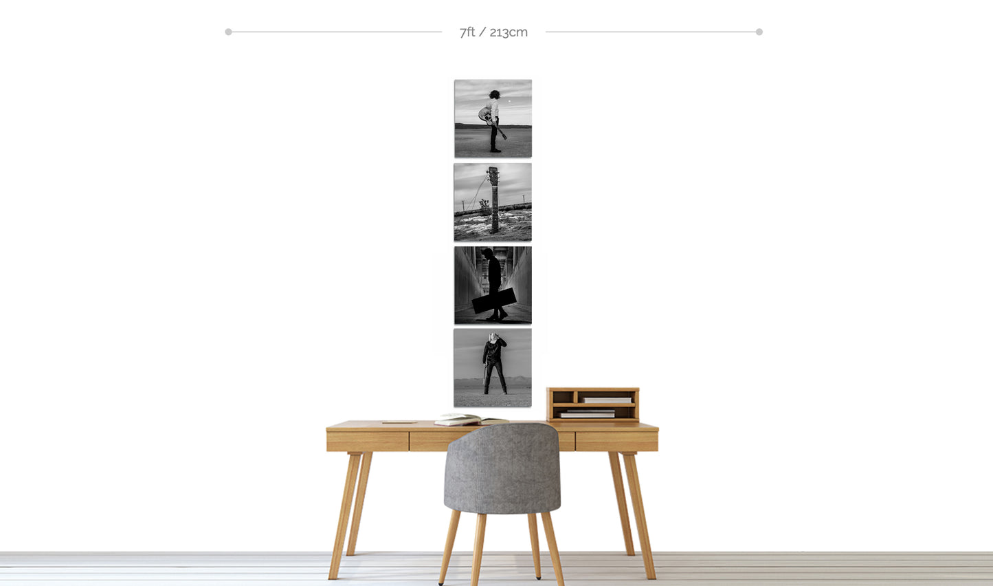 Set of four black and white fine art square metal prints displayed in vertical line hanging on wall above small home office desk with chair