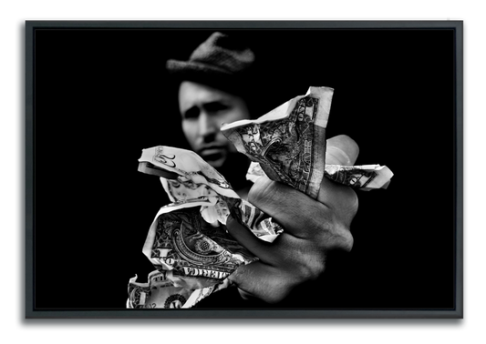 Black and white framed fine art photograph man wearing hat out of focus in background with hand outstretched holding fistful of money in foreground