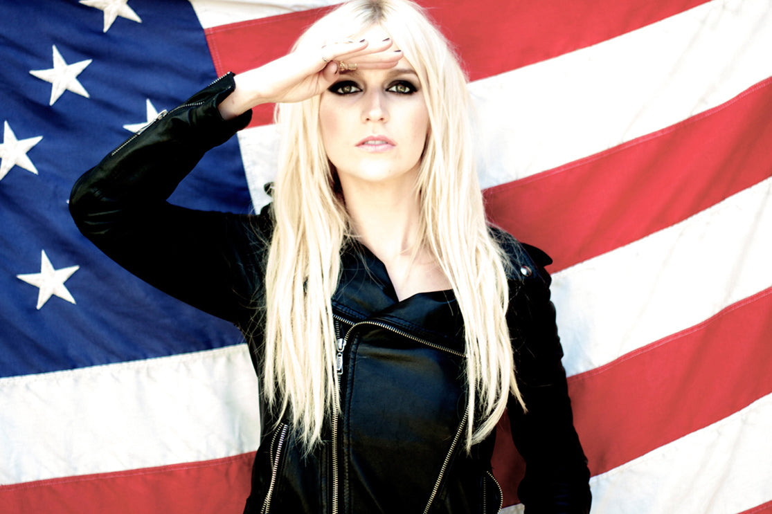 American Icon Art Competition Fine Art Portrait blonde woman in black leather jacket standing against American flag while saluting