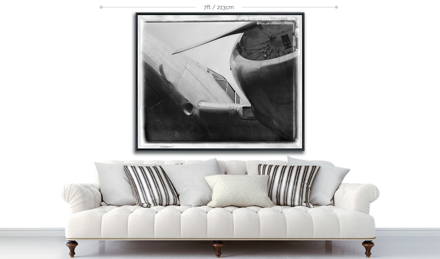 Polaroid metal print vintage airplane in black and white displayed above sofa