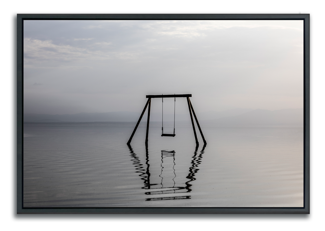 Swing set immersed in water photographed in muted colors