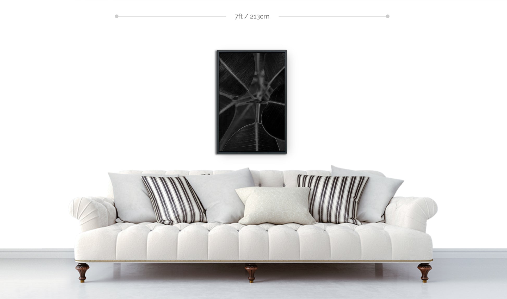 Framed botanical wall art preview black and white closeup photograph leaves growing from stem hanging above sofa