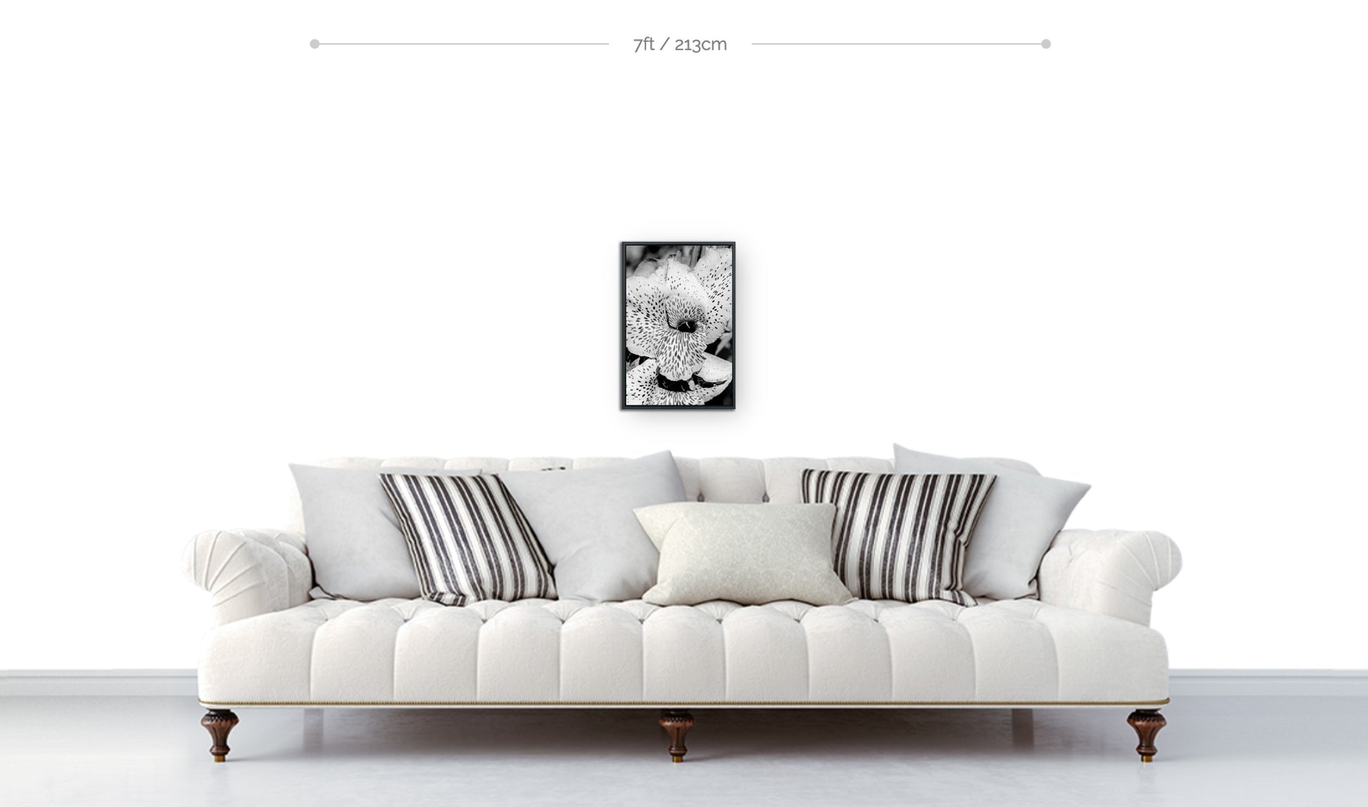 Floral wall decor example framed black and white spotted lily flower print shown hanging above sofa 18x12 size
