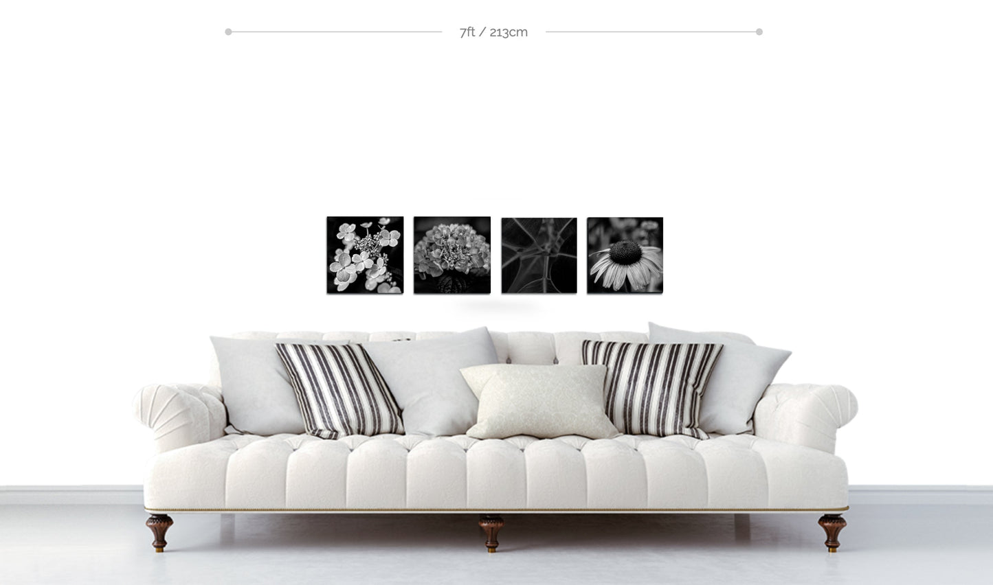Flower wall decor example four square metal botanical prints arranged in horizontal line above white sofa